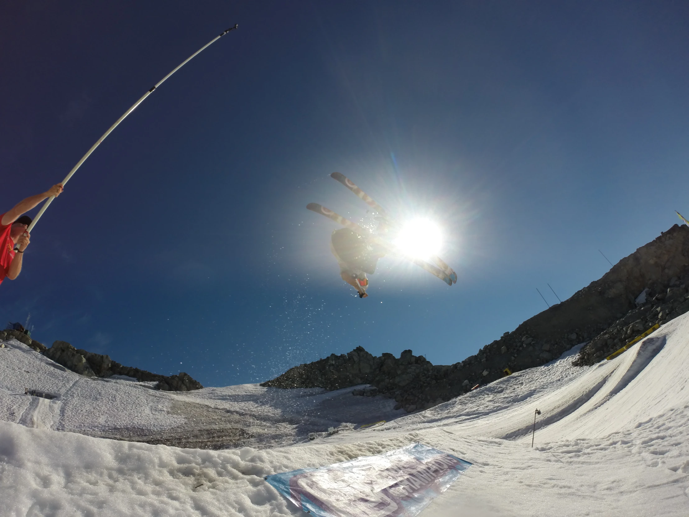 a person with a red jacket in mid air doing a trick on skis