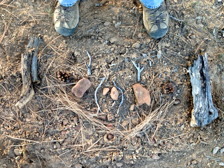 the persons feet are touching a circle made of rocks