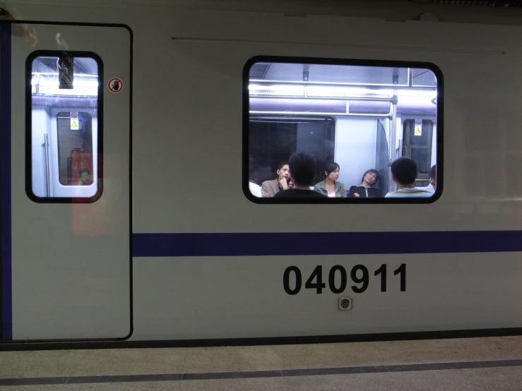 two people on a train near other passengers, in the reflection