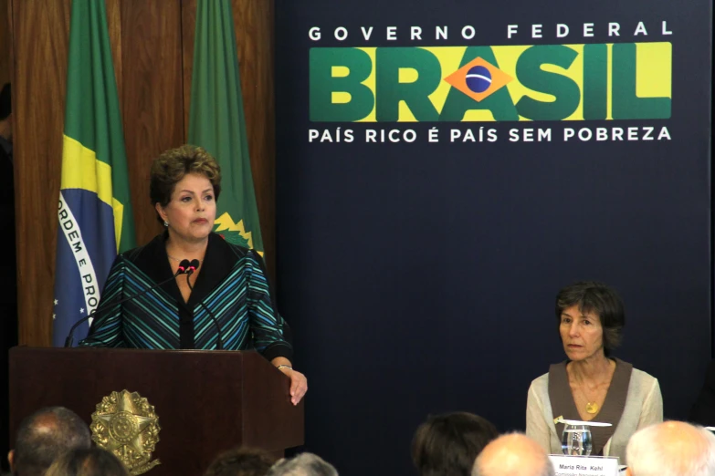 woman speaking from lecterge in front of crowd