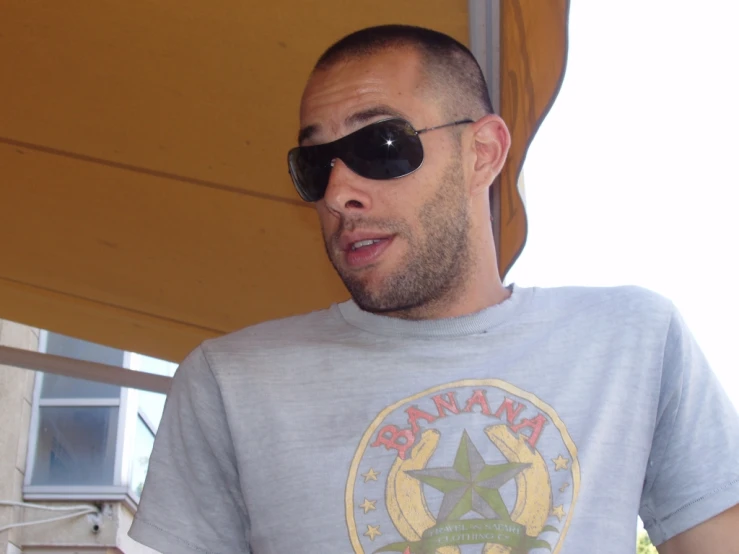 a man wearing a gray shirt and sunglasses