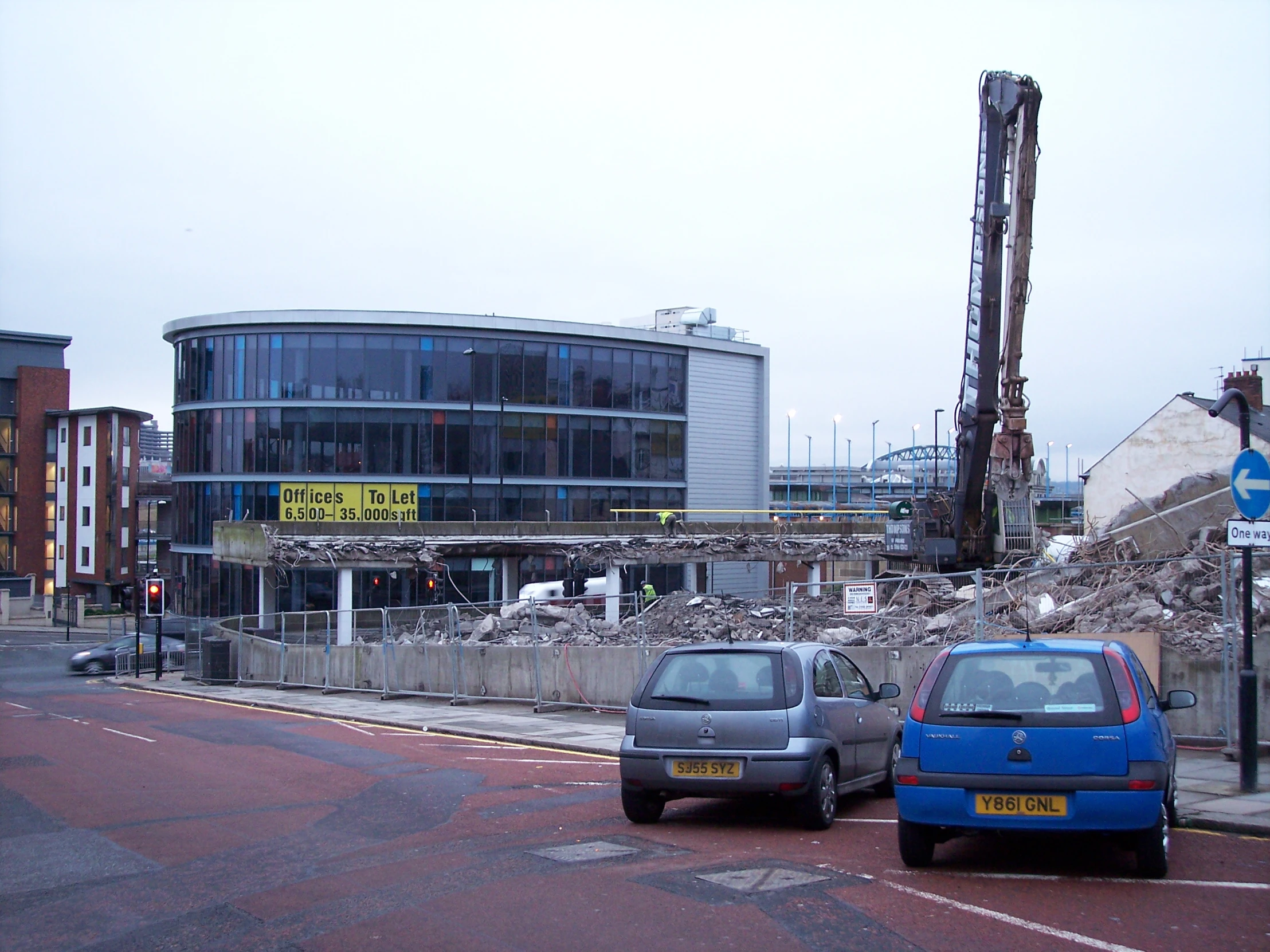 two small cars on a city street next to a building