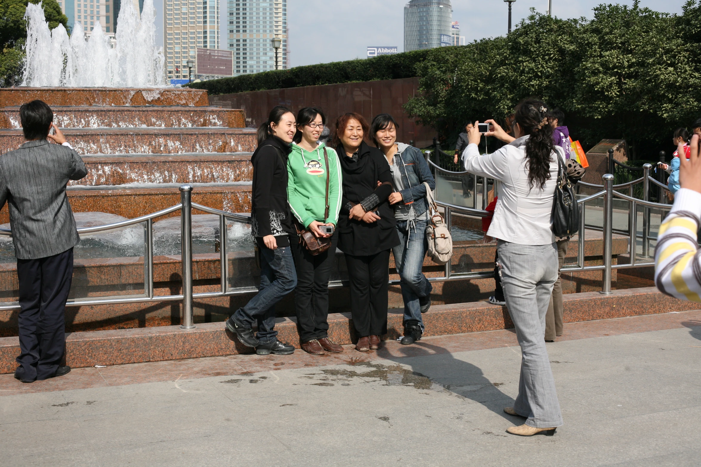 several young people taking pictures near the fountain