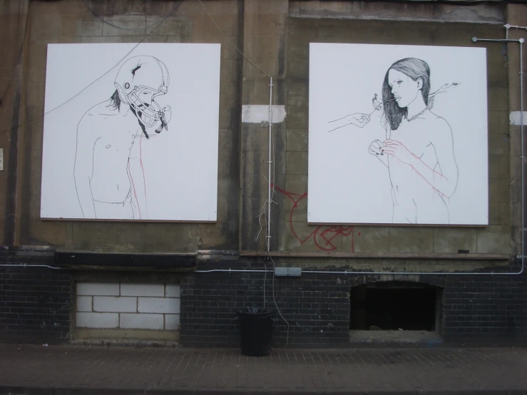 a wall with two drawing of people on it