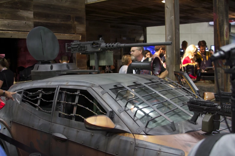 a futuristic vehicle parked inside a building next to a crowd