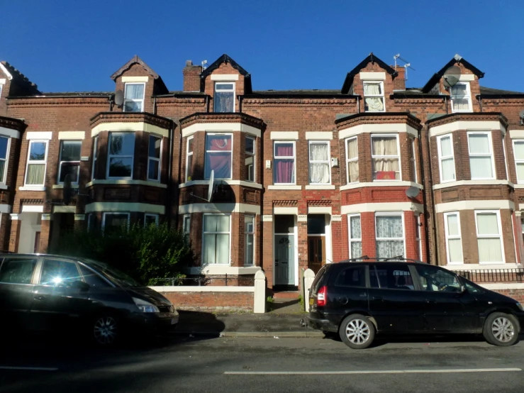 some cars are parked outside some brick buildings