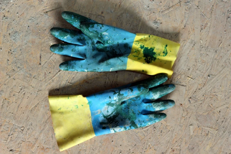 two blue and yellow gloves on top of each other