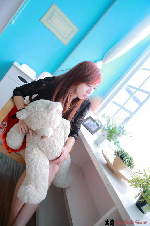 a young lady holds a large stuffed animal