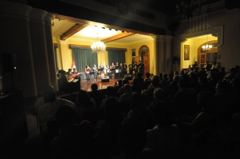 an orchestra plays on stage for a large audience