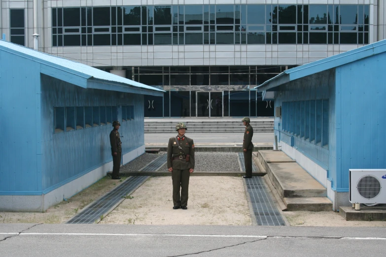 a man standing on a sidewalk in a courtyard with other men