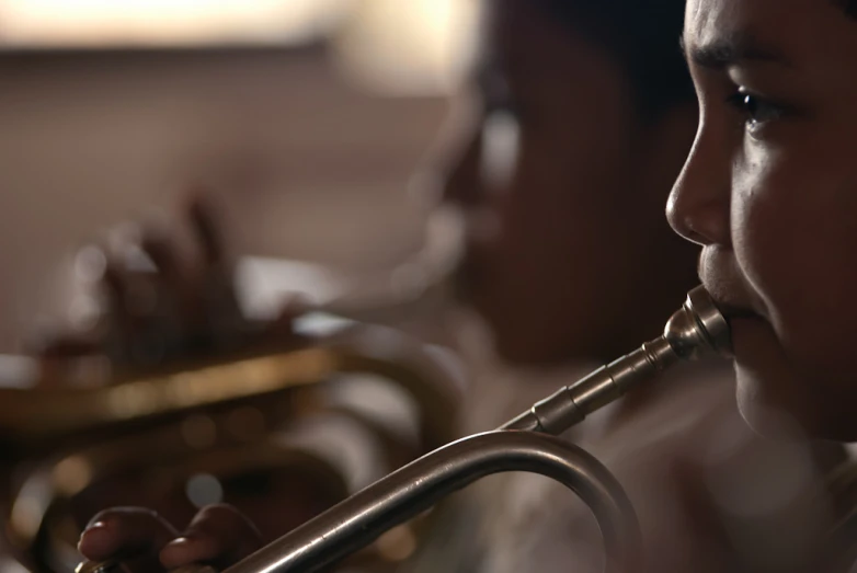 a little boy that is playing the trumpet