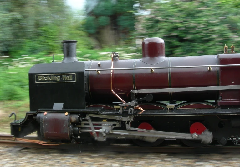 a very old steam locomotive driving down some tracks