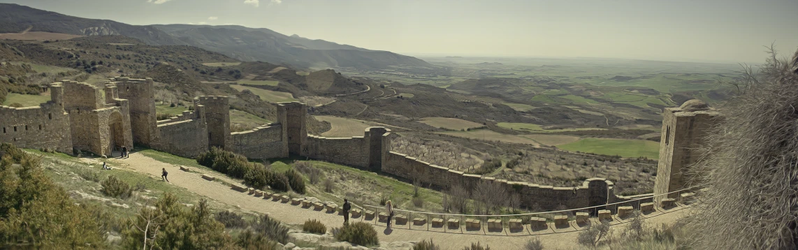 a castle sits on top of a mountain and is in the foreground