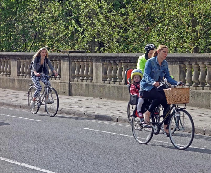 people riding bikes over an old bridge