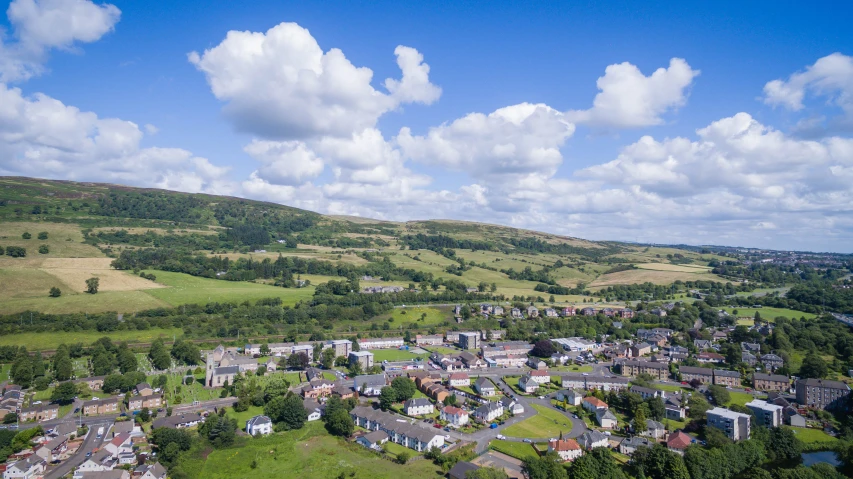 a small town in a green country surrounded by grass and trees