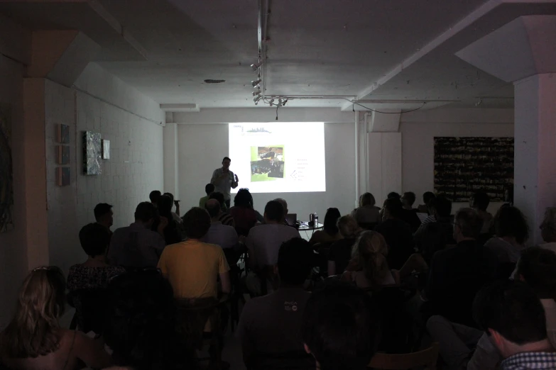 people in a room listening to an open presentation