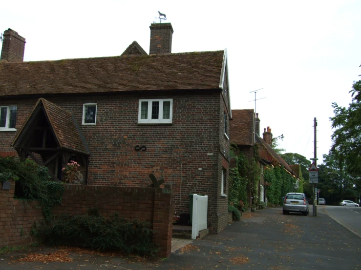 a street view of a brick house with a car parked in front