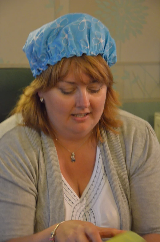 a woman wearing a blue hat looking down at her phone