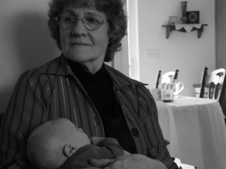 a woman in glasses holding a baby