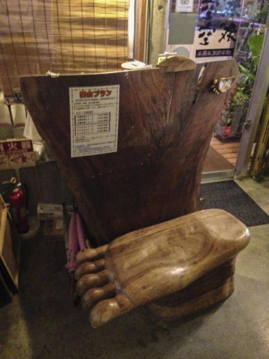 large wooden chair in the middle of shop next to window