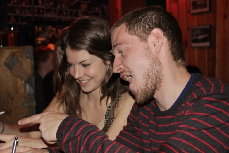 a man pointing a smart phone at another persons hand