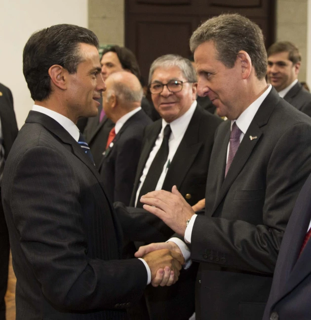 two men shaking hands with other men at an event