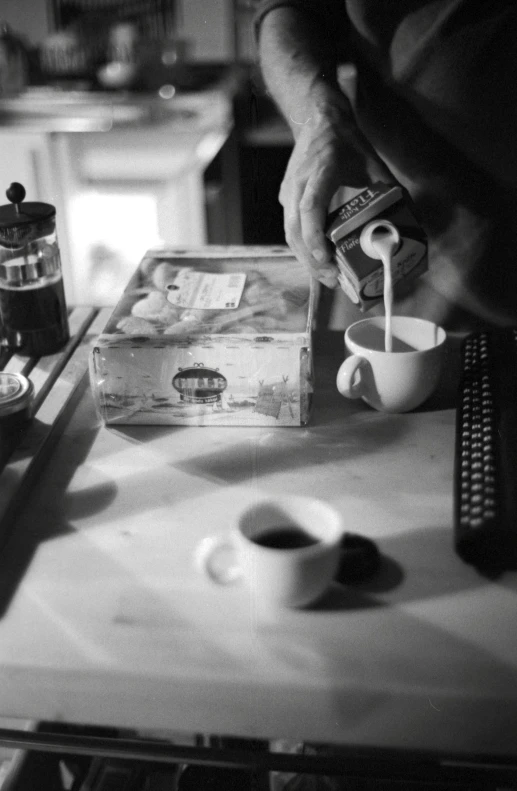 a black and white po of a man filling his coffee