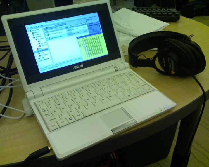 a laptop with headphones is sitting on a desk