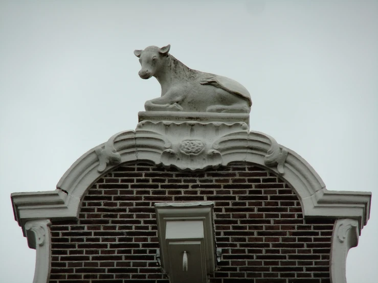 a tall stone lion on top of a building