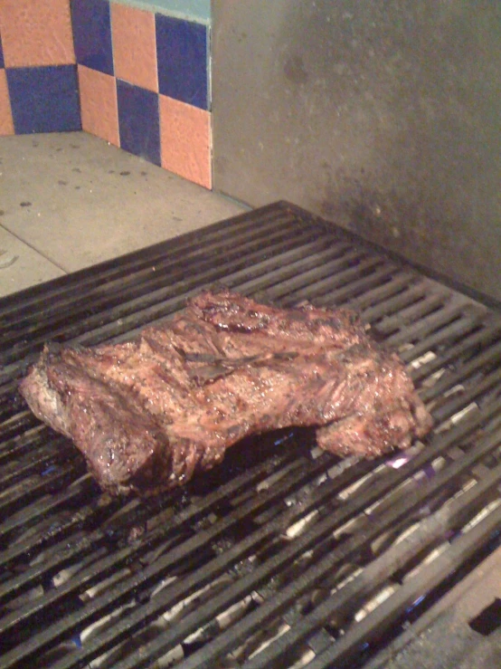 some meat on the grill with blue and orange tiles