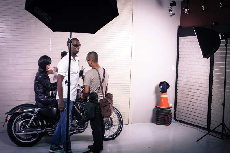 three guys behind a motorcycle in a po studio