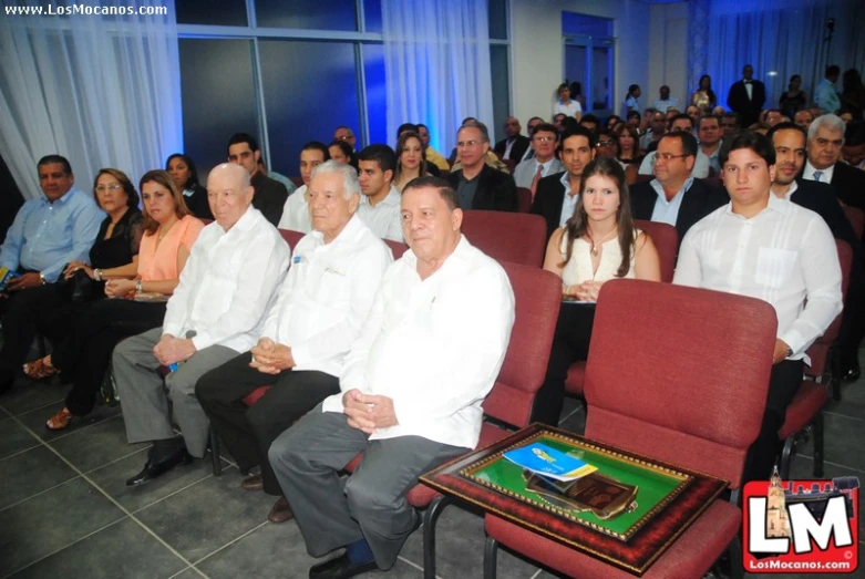 a group of people sitting in chairs and some looking towards the side