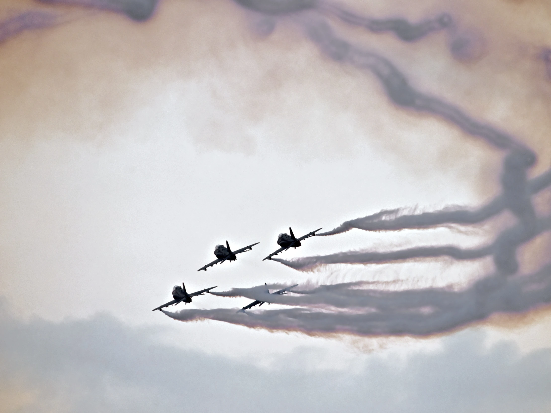 a squadron of jets flying in formation with streams coming out of them