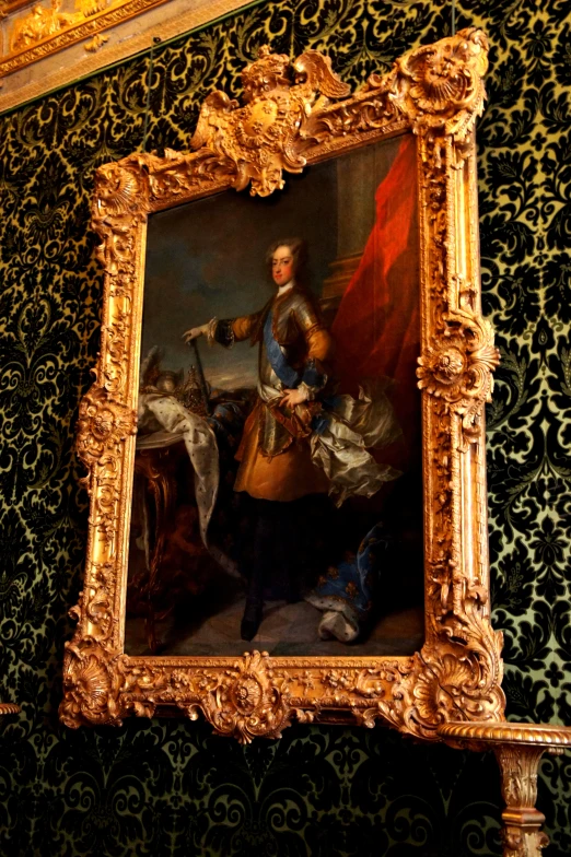 an ornate gold frame in a room with gold walls and patterned wallpaper