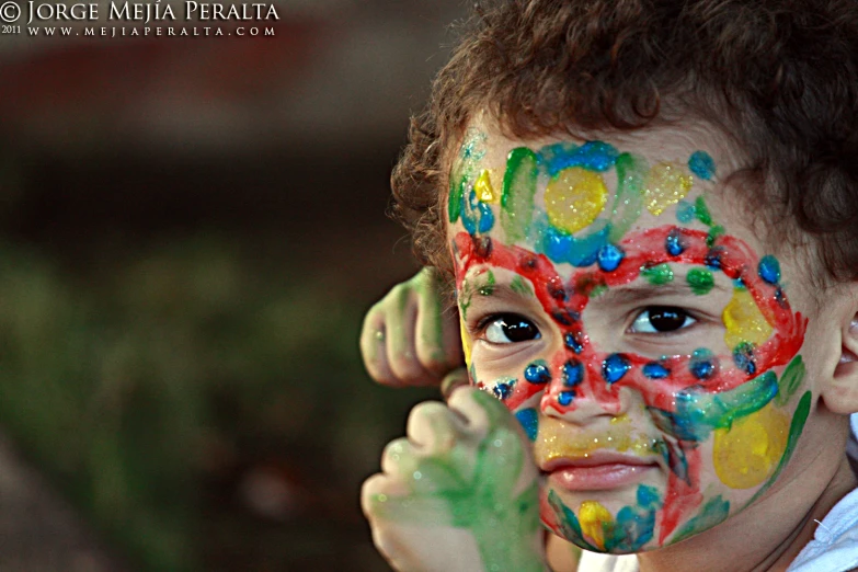a boy with a painted face posing for a picture