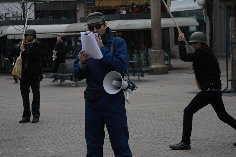 a man holding a white piece of paper in the middle of an open air plaza