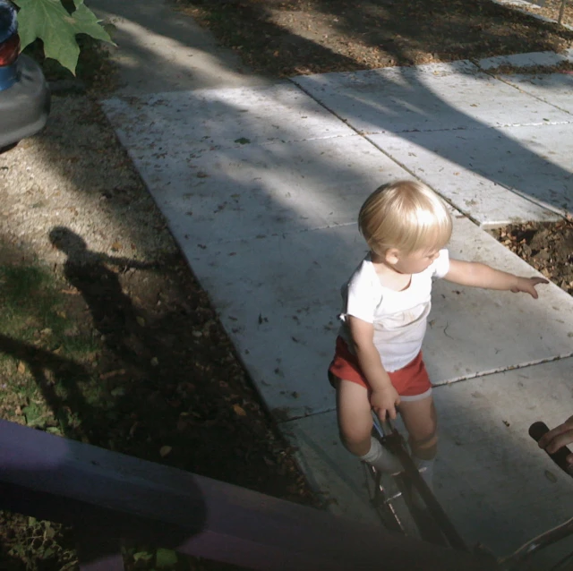 a little child standing on top of a wooden pole