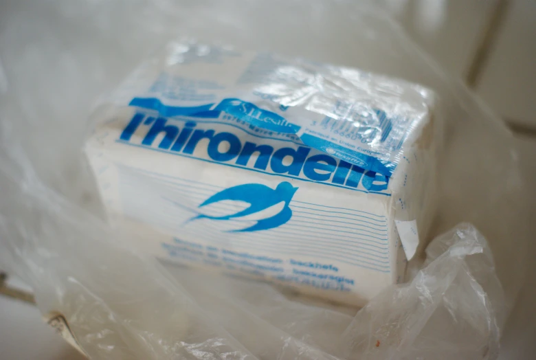 three packages of white toilet paper sitting in plastic