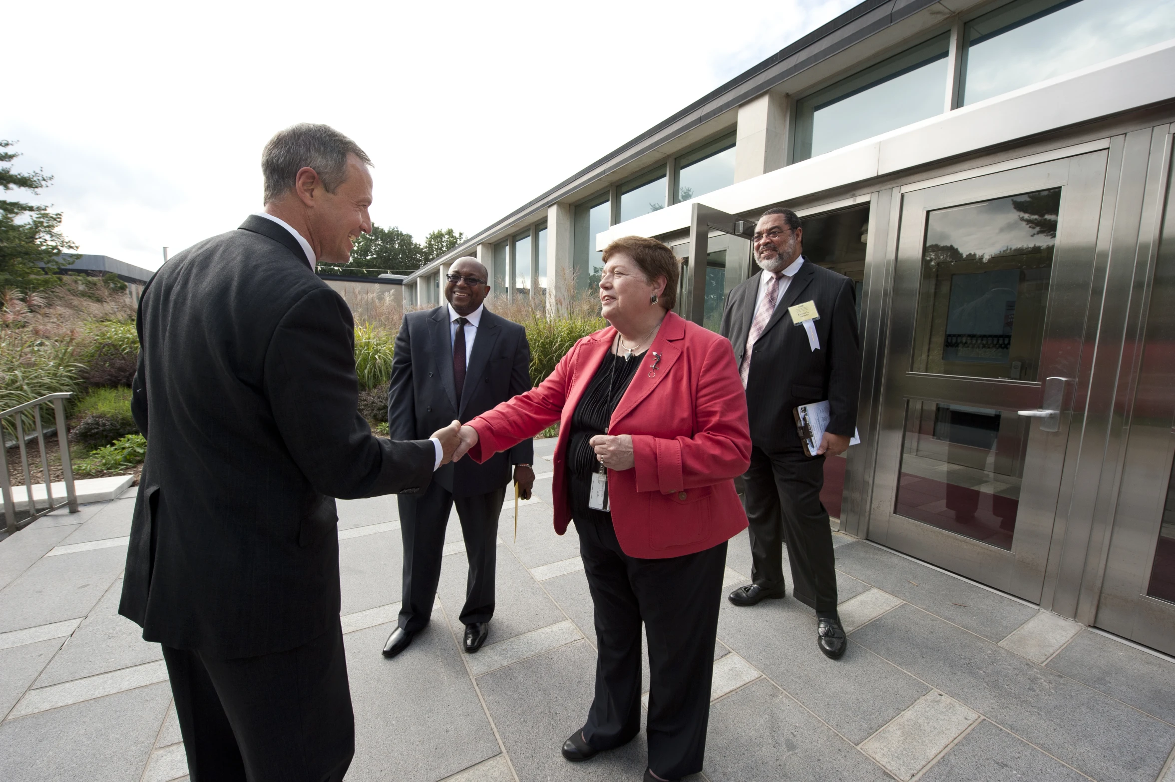 two women shaking hands at an open door