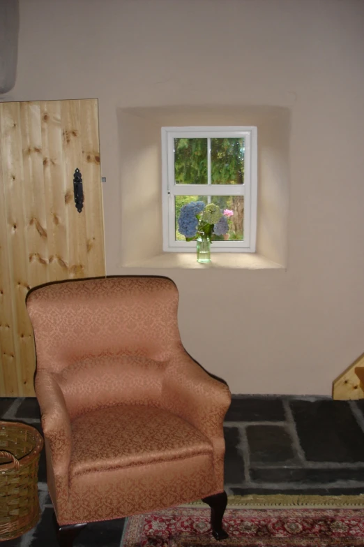 an empty chair sits against the wall near a window