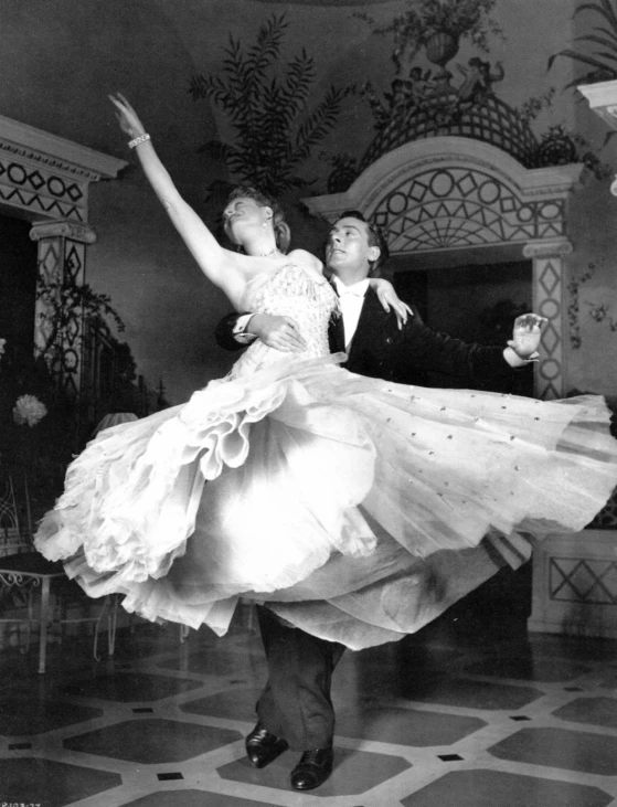 two people are dancing in a ballroom