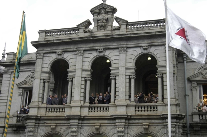 a crowd watches from the balcony of a building