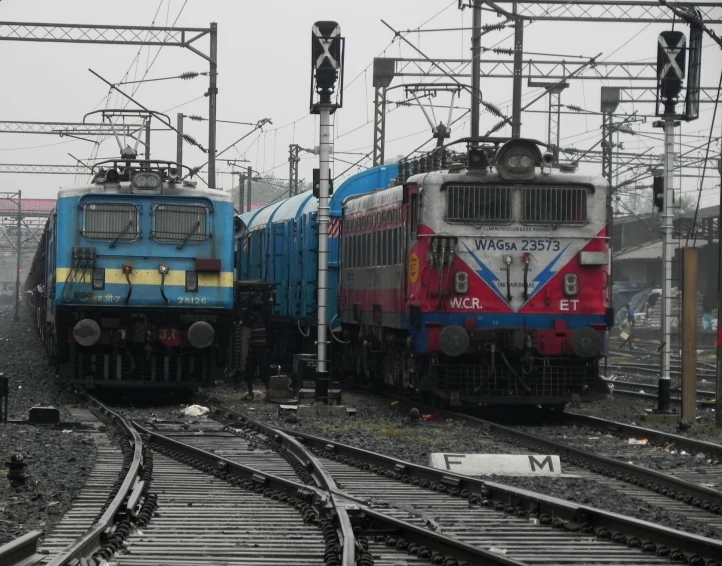 two trains sitting side by side in a train yard