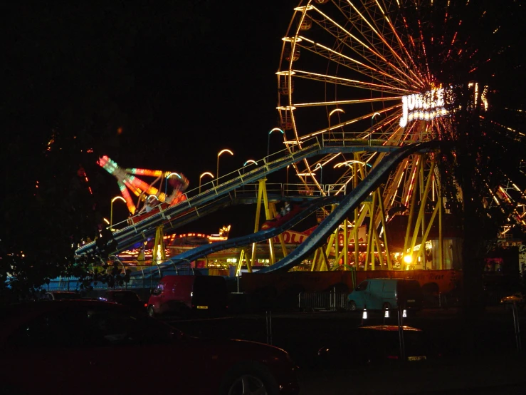 an amut park at night with ferris wheel and ferris coaster
