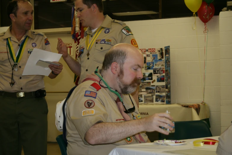 a man in uniform drinks from a glass