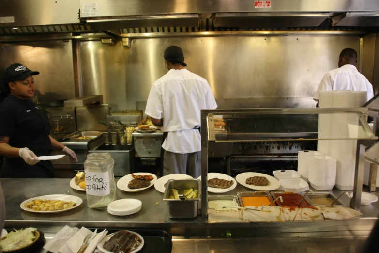 cooks are preparing food in a large commercial kitchen