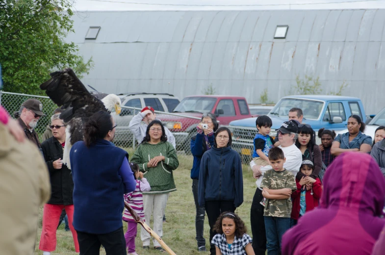 a crowd is watching a woman stand near a baseball bat