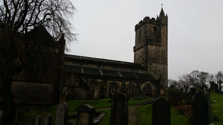 this is an old graveyard with graves and a tall tower