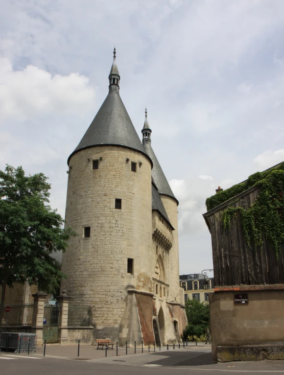 a large stone tower structure next to a tall building