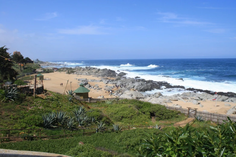 beach with people enjoying the sunny weather near the ocean